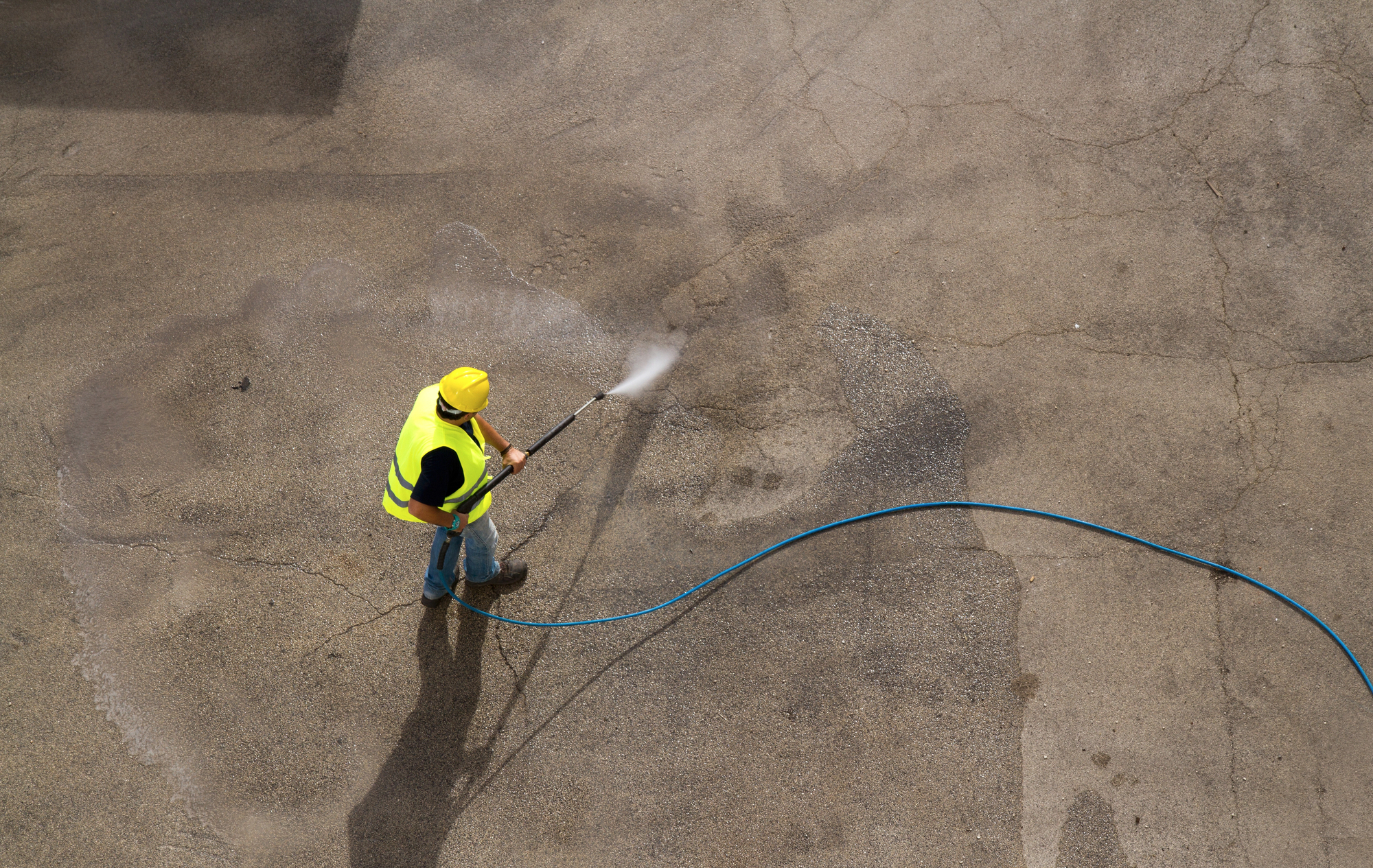  Worker in hard hat pressure washing 