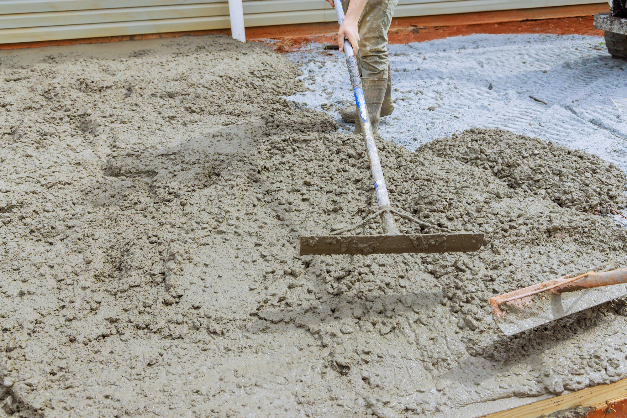 An employee of construction company uses special tool to level concrete