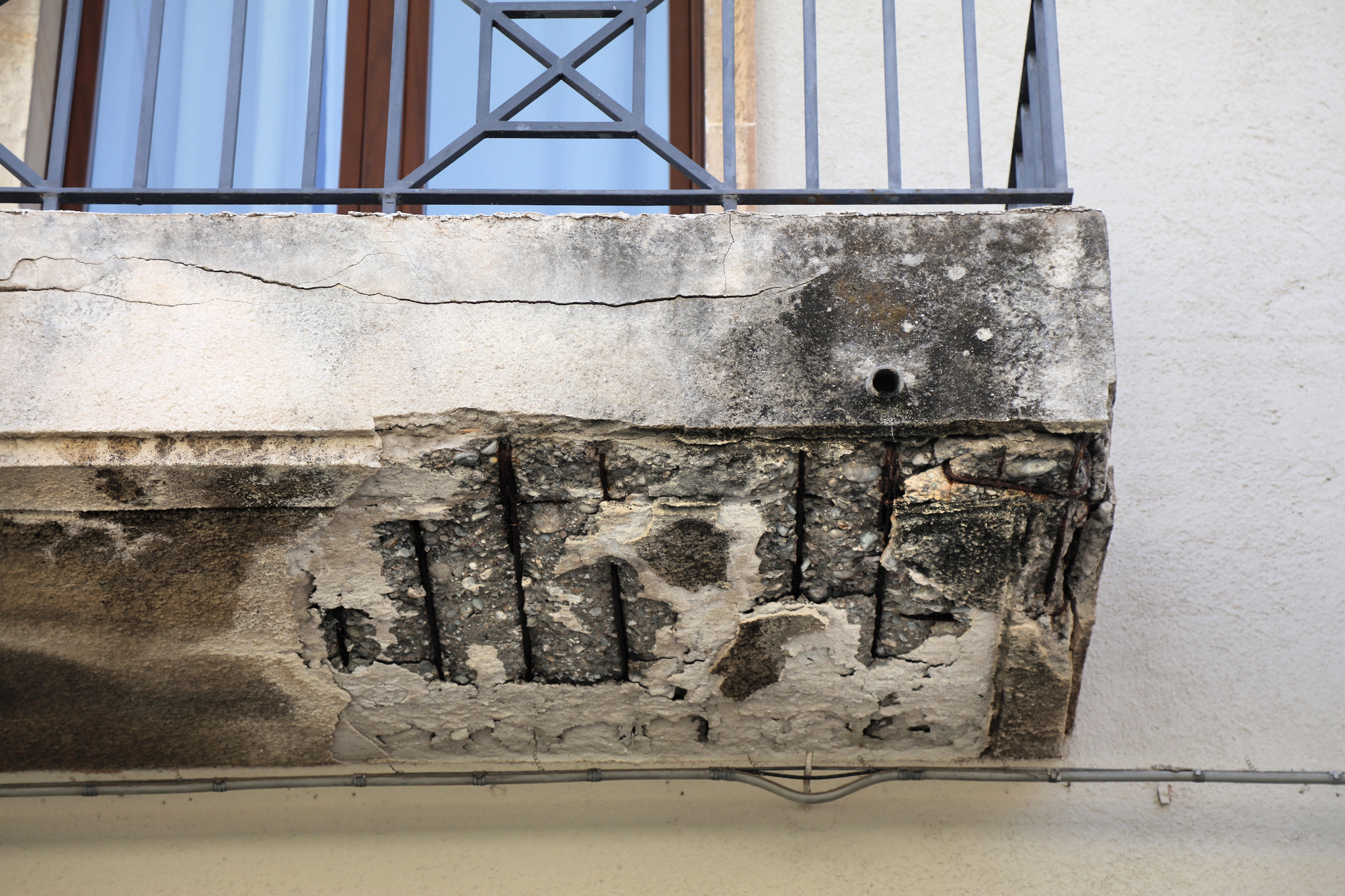 Weather damage of concrete. Flaking concrete on the balcony 